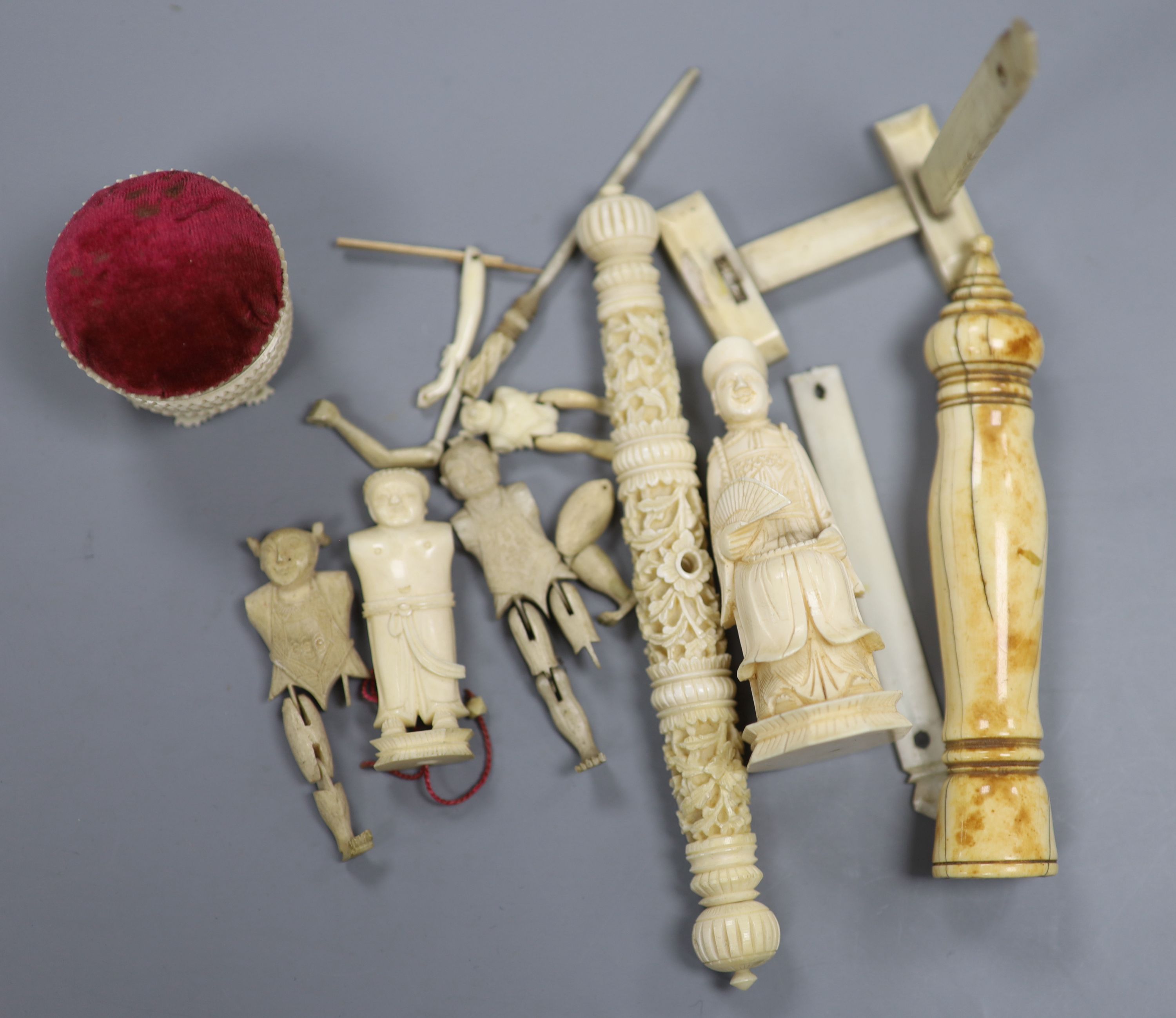 Three Chinese articulated ivory models of acrobats, two chess pieces, an ivory brush handle and needlework items